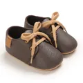 Detailed macro view of brown textured leather infant walker shoes with soft tan laces - Dark Gray