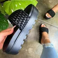 Detail of women's black woven platform sandals showing braided strap and thick sole. - 35 / Black
