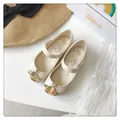 Detalle de zapatos jelly beige para niña con hebilla icónica de emblema de orbe dorado - Blanco