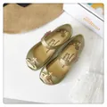 Vista superior de zapatos jelly dorados con purpurina y el icónico amuleto orb - Dorado