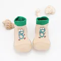 Detailed view of beige baby sock shoes with green ribbing and cute cartoon character - Khaki Cartoon Letter B