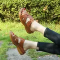 Close-up of stylish brown wedge sandals for women with perforated cross straps - Brown
