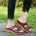 Close-up detail of burgundy platform wedge sandals featuring laser-cut criss-cross straps - 35 / Jujube Red
