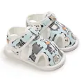 Detalle de sandalias para bebé en azul claro con estampados de animales y cierre de velcro - Azul claro