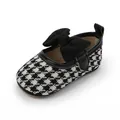 Detailansicht der Baby-Mädchen-Prinzessin-Schuhe mit Hahnentrittmuster und Samtschleife - Schwarz