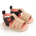 Close-up of baby girl summer sandals with woven straps and heart detail - Apricot