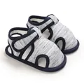 Primer plano de sandalias para bebé de suela blanda con tejido jaspeado - Gris