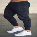 Close-up of men's slim-fit black joggers with drawstring waist and ribbed cuffs - S / Bottoms / Black
