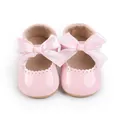 Detailansicht der rosa Baby-Prinzessin-Schuhe mit großer Satinschleife und Wellenrand. - Rosa