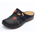 Detailed view of floral applique and contrast stitching on navy and black mules - Dark Blue