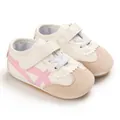 Detail view of baby walking shoes with pink crossed stripes and soft soles - Pink (Full PU)