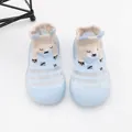 Detailopname van lichtblauwe babysok-schoenen met een schattig beerpatroon en zachte zool - Blauw
