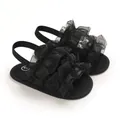 Elegantes sandalias negras para bebé con volantes, suelas blandas y tiras traseras elásticas. - Negro