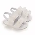 Detalle de sandalias de bebé con encaje blanco y correa elástica - Blanco