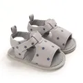 Détail rapproché de sandales pour bébé grises avec étoiles bleues et semelles souples - Étoile grise