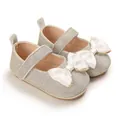 Close-up detail of silver glitter baby princess shoes featuring elegant white satin bow design - Gold