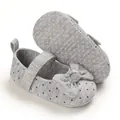 Detail view of grey polka dot baby girl soft sole walker shoes with bow decoration. - Gray