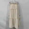 Front view of a cream tiered ruffled sleeveless sundress displayed on a clear mannequin - Apricot