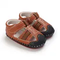 Primer plano de sandalias para bebé en cuero sintético marrón con suelas de goma suave - Marrón