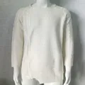 Vista macro detallada que muestra el intrincado punto de ochos y la textura acanalada de este jersey - Blanco