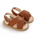 Detalle de sandalias de bebé en cuero sintético marrón con suelas de tela suave - Marrón
