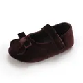 Detaillierte Nahaufnahme weicher Baby-Mary-Jane-Schuhe aus Samt in Dunkelrot mit Schleife - Braun
