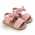 Dettaglio sandali rosa per neonata con grande fiocco decorativo e bordi smerlati - Rosa