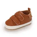 Close-up of brown faux leather baby walking shoes with dual hook-and-loop straps - Brown