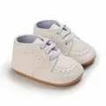 Detailed view of elegant white faux leather infant walking shoes with soft rubber soles - White
