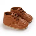 Close-up detail of brown textured faux leather baby walking shoes with flexible soft soles. - Brown