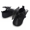 Nahaufnahme von eleganten schwarzen Baby-Prinzessin-Schuhen mit einer großen Netzschleife - Schwarz