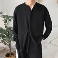 Dettaglio del cardigan nero minimalista a maniche lunghe da uomo indossato dal modello - Nero