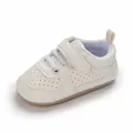 Vista detallada de zapato de bebé crema con suela de goma blanda y diseño perforado - Blanco