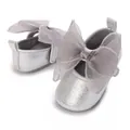 Detail von silbernen Glitzer-Babyschuhen mit einer großen, durchsichtigen grauen Schleife - Silber