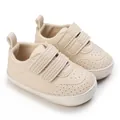 Nahaufnahme von beigen Baby-Lauflernschuhen mit Klettverschluss und Lochleder - Aprikose