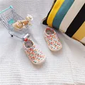 Detailed view of baby canvas slip-on shoes with orange floral print and soft sole. - Full Print Cherry
