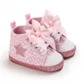 Dettaglio ravvicinato delle scarpe per neonati con stampa leopardata rosa e grande fiocco - Lunghezza Interna 11cm / Glitter
