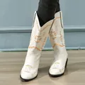 Close-up detail of stylish white mid-calf cowboy boots with vibrant orange embroidery - 35 / White