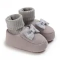 Vue détaillée de ces chaussons tricotés pour bébé ornés d'un joli nœud décoratif - Gris