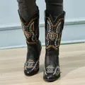 Close-up view of the intricate folk embroidery on black mid-calf women's boots - 35 / Black