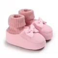 Détail de chaussons en tricot rose pour bébé avec semelles souples et nœuds décoratifs - Rose