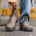Gros plan de bottines Chelsea en cuir marron avec côtés élastiques et languettes. - Marron