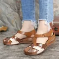 Close-up detail of women's casual color-block wedge sandals with velcro strap on feet - 35 / Brown