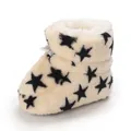 Vista detallada de botas de invierno de felpa para bebé con estrellas negras y forro. - Albaricoque