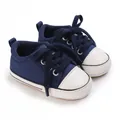 Detailansicht der dunkelblauen Leinwand Babyschuhe mit weichen weißen Gummisohlen. - Blau