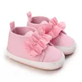 Primer plano de zapatos de bebé rosa con suela blanda y lindo detalle de volantes - Rosa