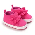 Detalle de zapatos de bebé rosa fucsia con volantes y suela blanda - Rosa rojo
