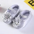 Detail von silbernen Satin-Babyschuhen mit großen Bandschleifen und Glitzersteinen. - Strassblume Silbergrau (GZ809)