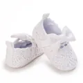 Nahaufnahme weißer Baby-Prinzessinenschuhe mit zarter Spitze und eleganter Schleife. - Weiß