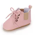 Primer plano de zapatos rosas de suela blanda para bebés con cordones y detalle elástico - Rosa